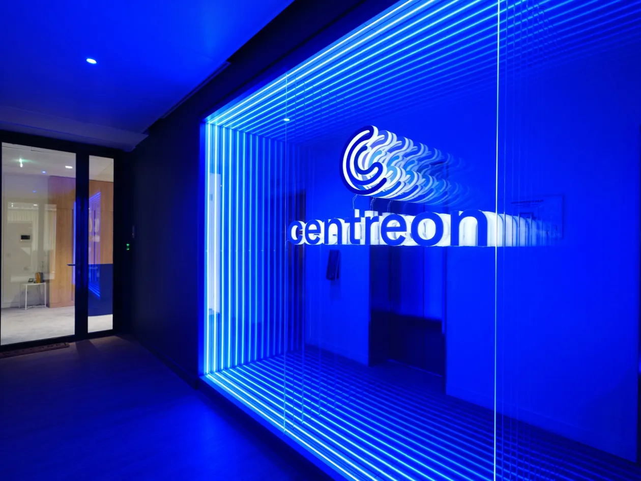 Entrance of Centreon's Paris office, with the Centreon logo lit in blue behind a glass wall
